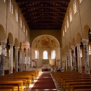 Il solenne e arcaico interno a tre navate della basilica di Sant’Eufemia.